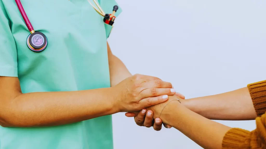 Mãos dadas entre médica e gestante