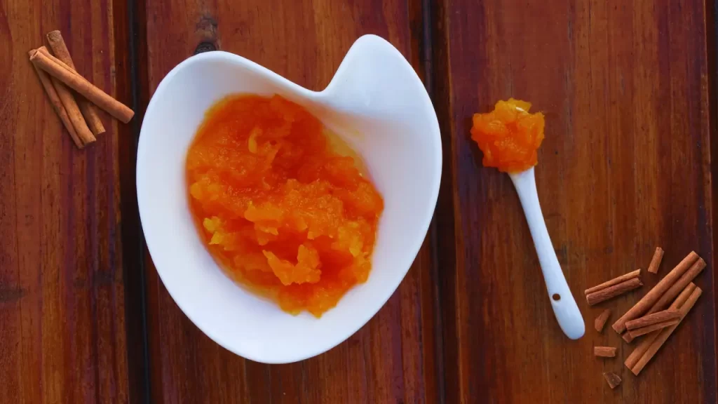 Tigela com doce de abóbora cremoso tradicional com canela em pau