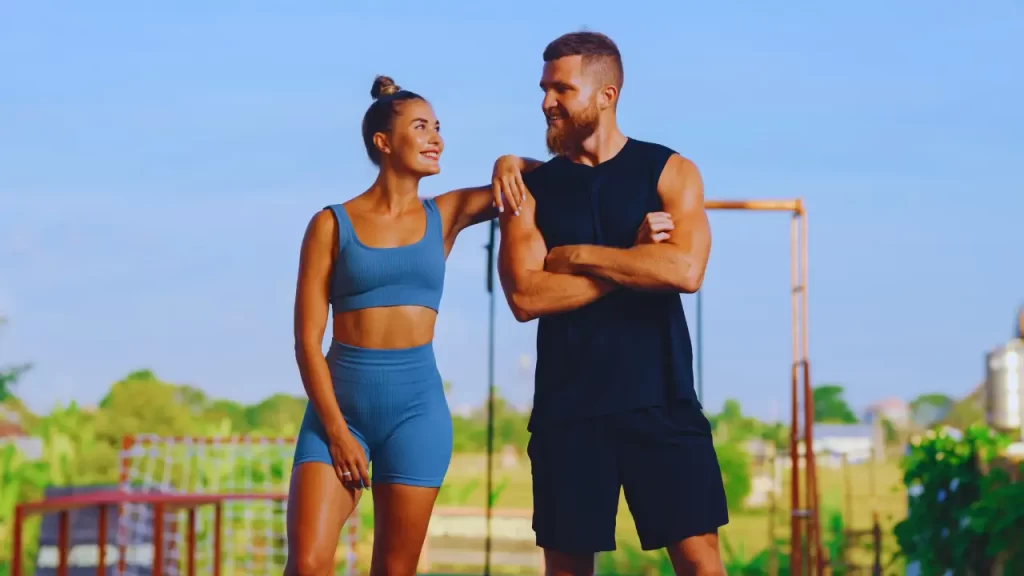 Casal na academia ao ar livre, contribuindo pra saúde mental