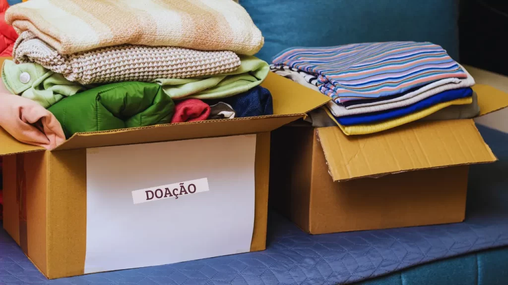 Pessoa separando roupas para doar aplicando o Seiri do Método 5S.